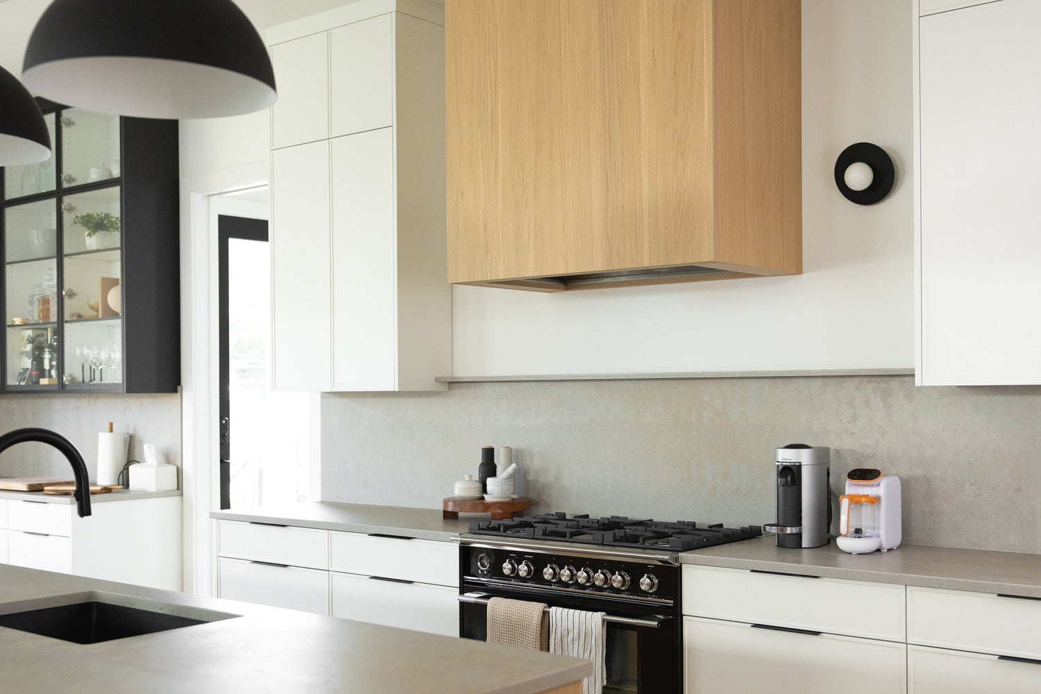 Modern kitchen with Quark Baby fruit feeder comparison setup on black range cooktop