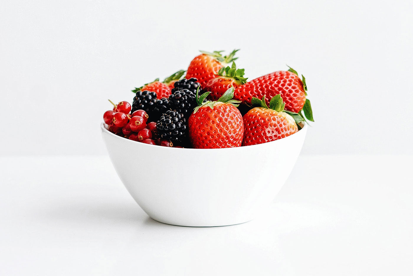 Quark Baby brain-boosting berries in white bowl for kids' nutrition and development.