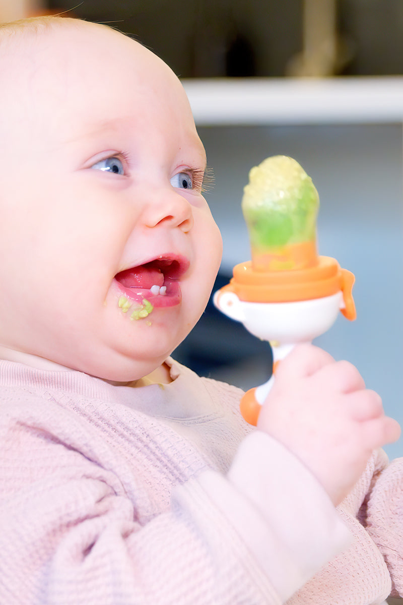 Baby eating fresh fruit from a Quark Fruuti silicone baby fruit feeder