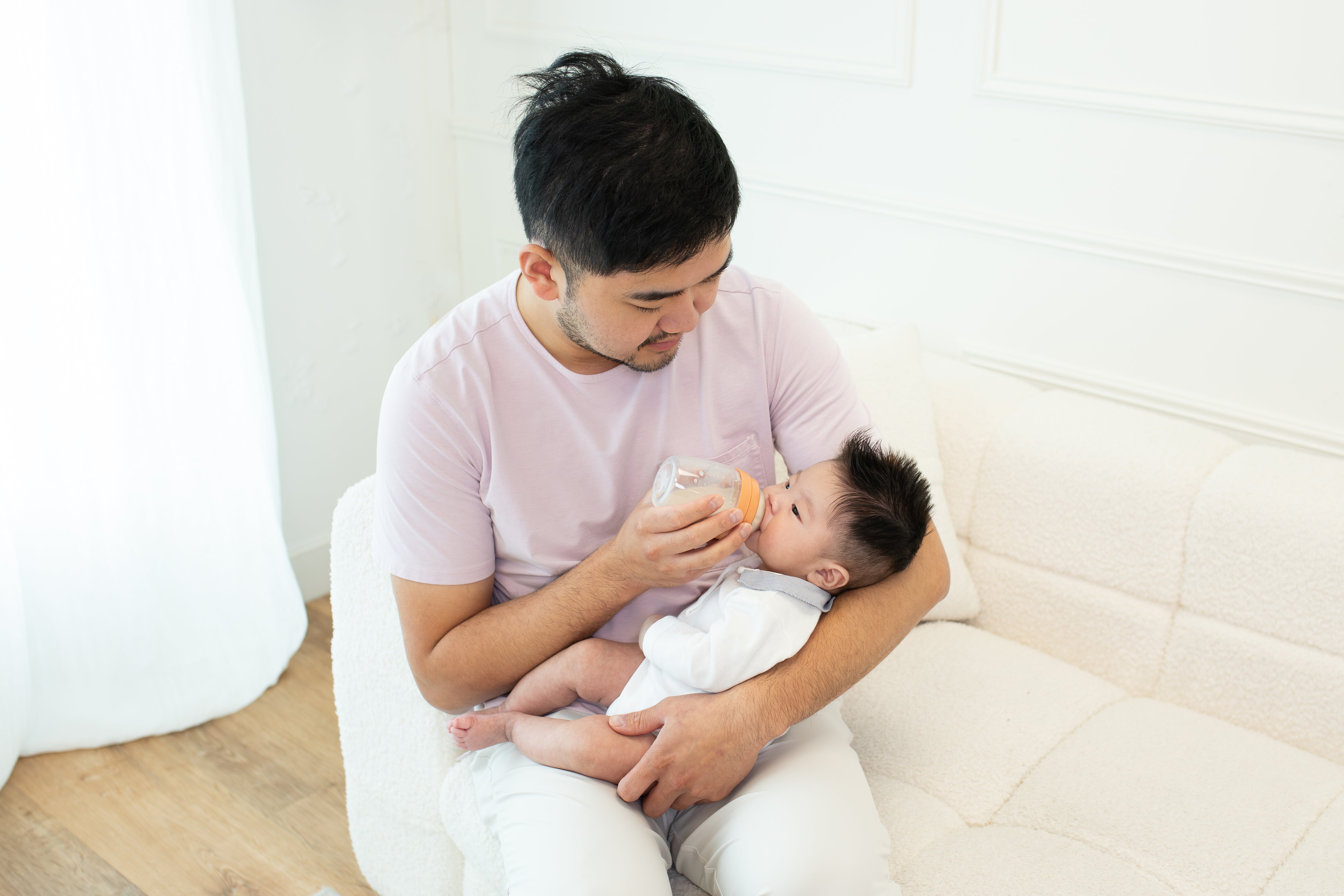 Father feeding infant with Quark Baby bottle during outdoor activity
