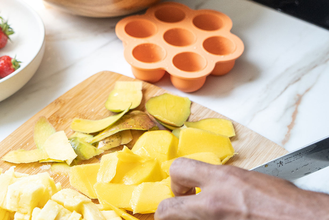 Quark Baby silicone mold and fresh produce on cutting board for baby meal prep planning.