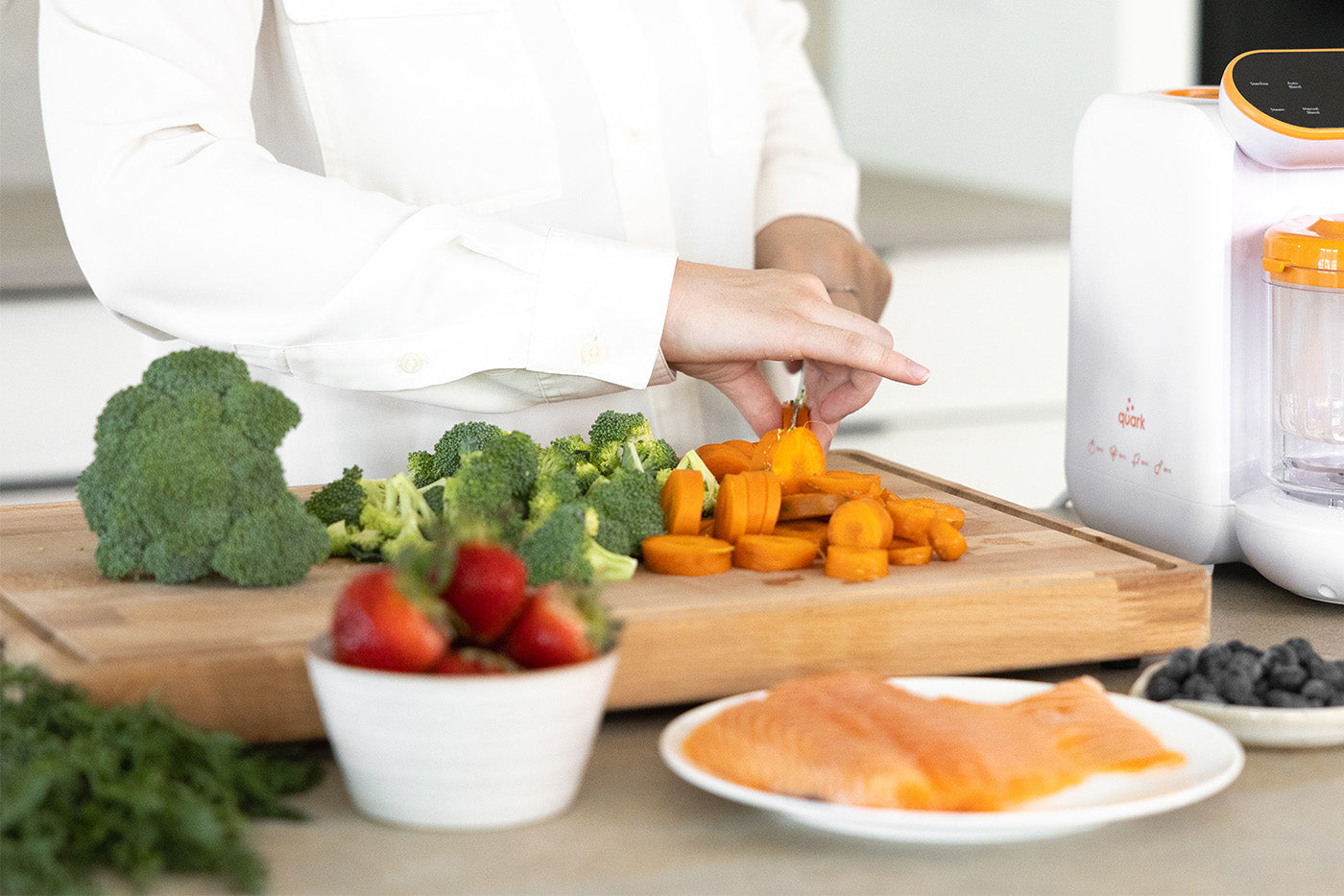 Parent preparing fresh vegetables with Quark Baby bottle for back-to-school meal prep.