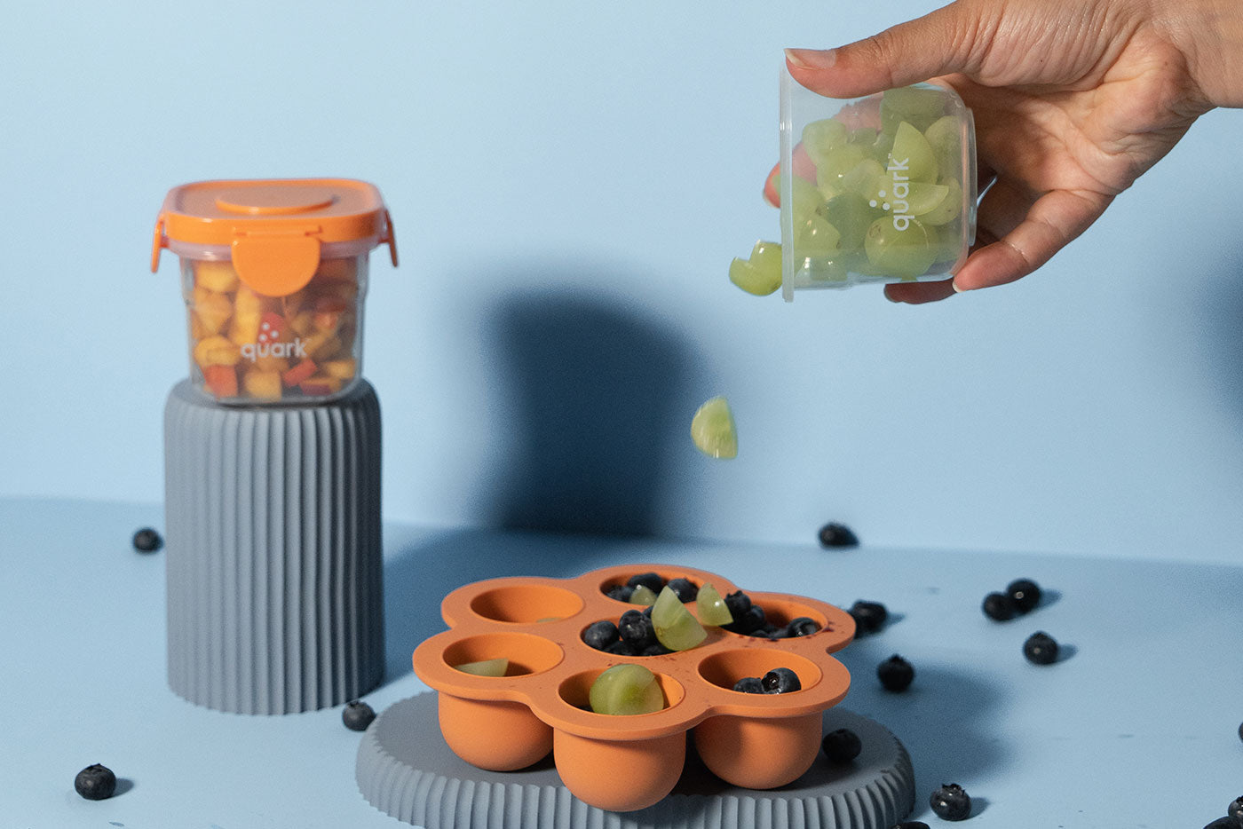 Quark Storii orange feeding pods filled with grapes and blueberries