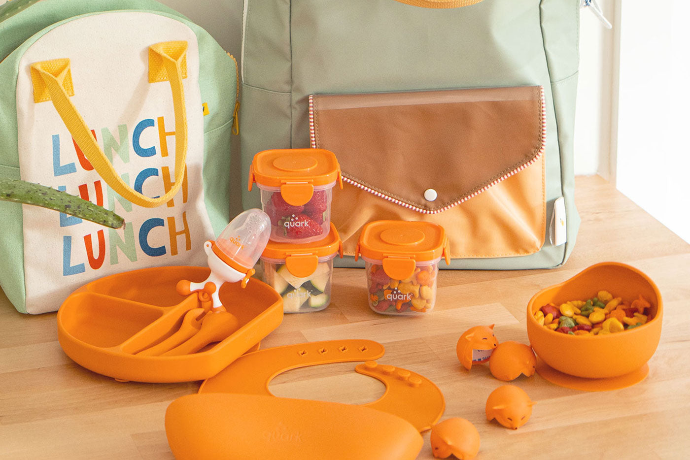 Quark Baby orange feeding set with lunch bag, containers, plate, and utensils for toddlers.