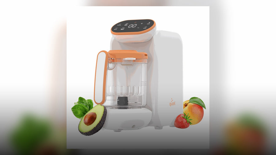 Quook baby food maker on a kitchen counter with its blending cup and steam basket