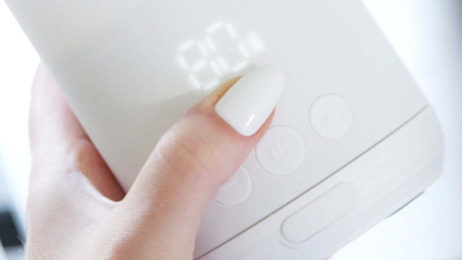 Quark Baby BuubiBottle portable warmer control panel in caregiver hand