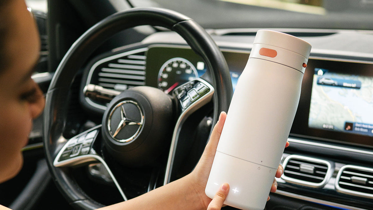 BuubiBottle Portable Milk Warmer PRO held in a car during a journey