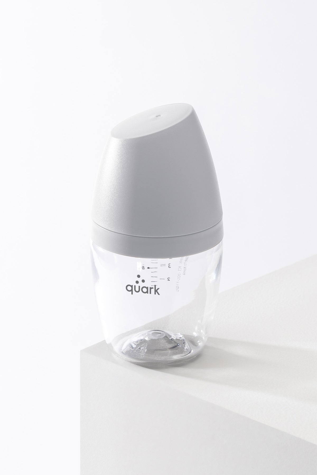 BuubiBottle Mini 5oz grey newborn bottle on pedestal — shatterproof Swiss Grilamid TR-90 baby bottle, glass-clear without the risk
