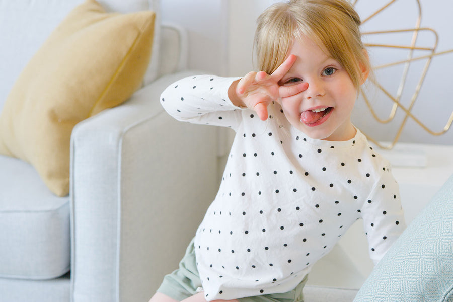 Toddler in polka-dot shirt smiling during playtime, Quark Baby lifestyle moment