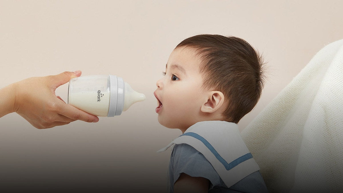 Parent offering a BuubiBottle Max to a seated baby during a feed