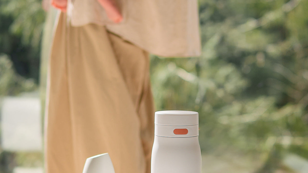 BuubiBottle Portable Milk Warmer PRO with its cap beside it, ready to pack