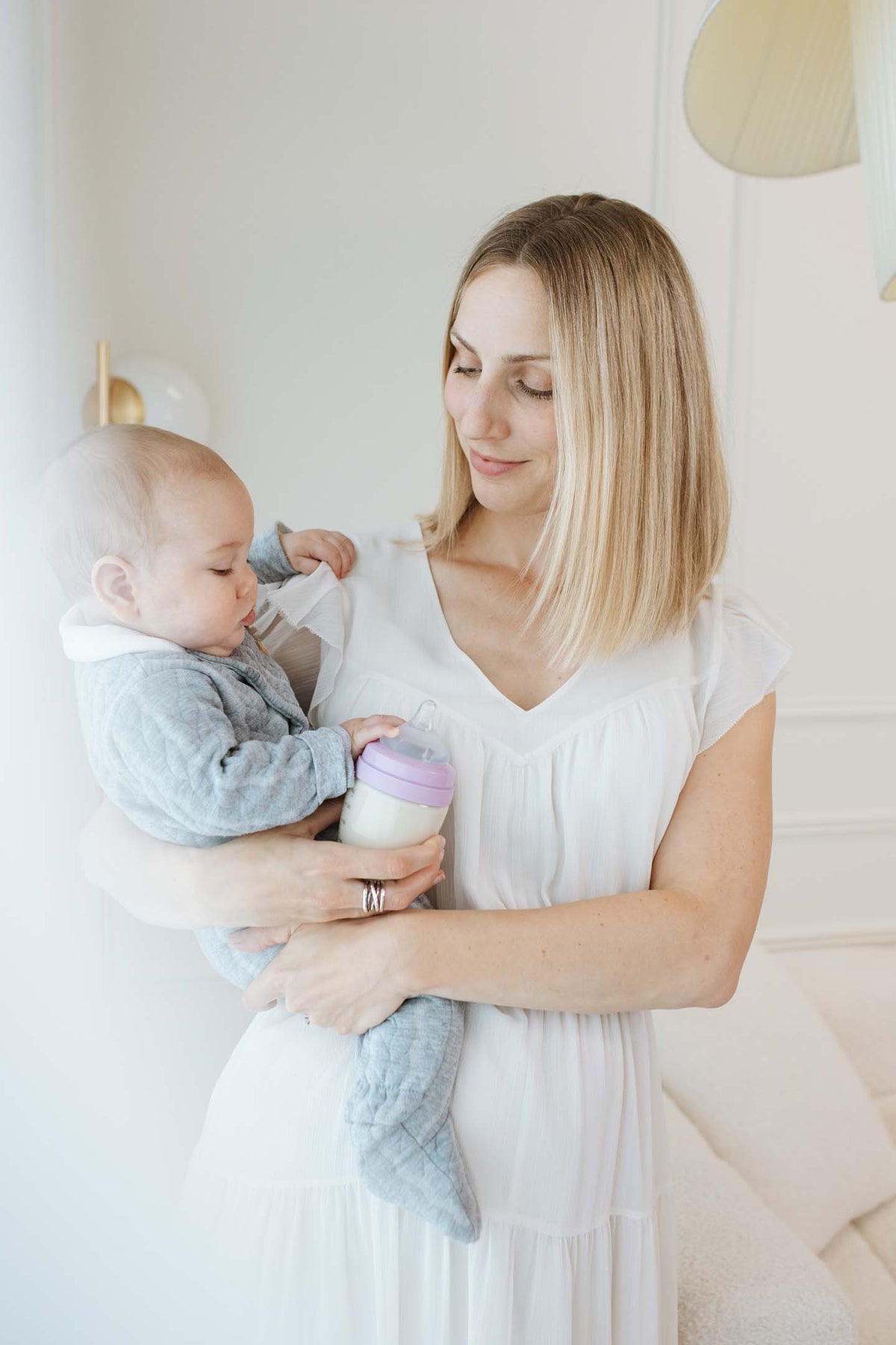 Mother holding infant with Quark BuubiBottle Hybrid Feeding Bundle bottle