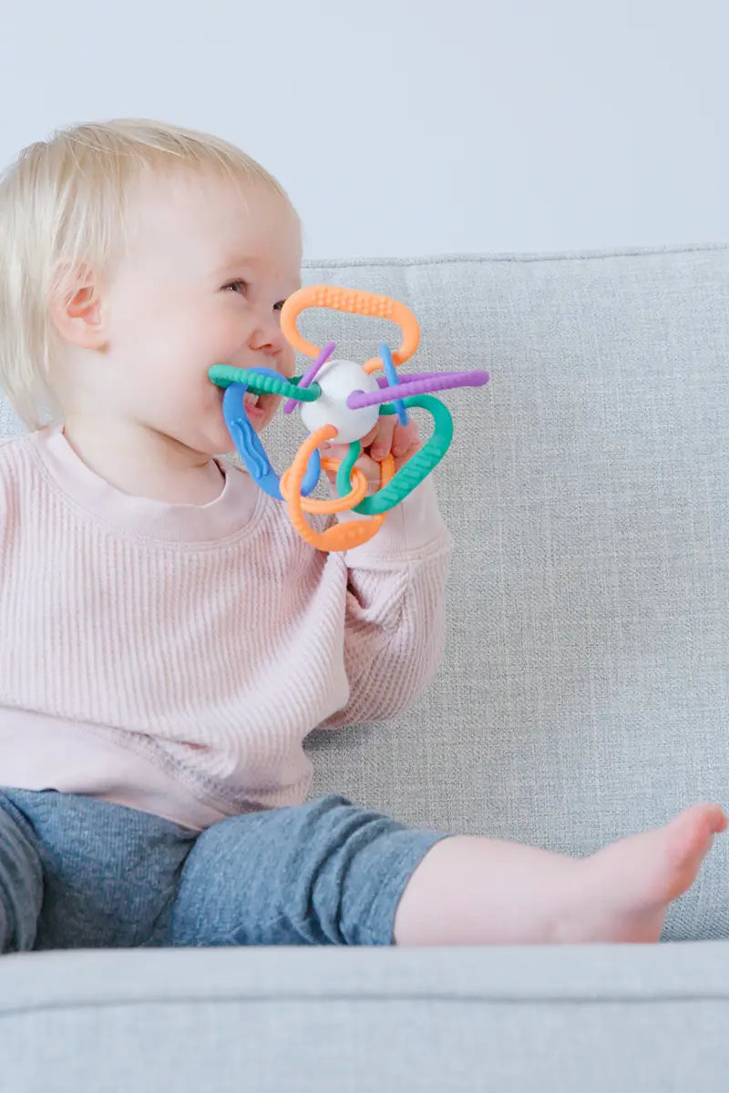 Baby chewing colorful Quark Thiingy sensory teether with textured rings and handles